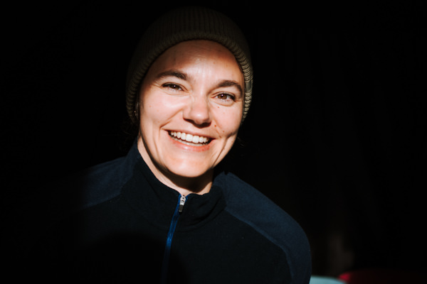 Portrait von Michelle Wegener mit Mütze auf und Sonne im Gesicht