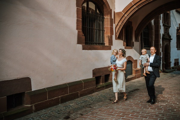Paar mit Kindern auf dem Arm nach standesamtlicher Trauung in Freiburg