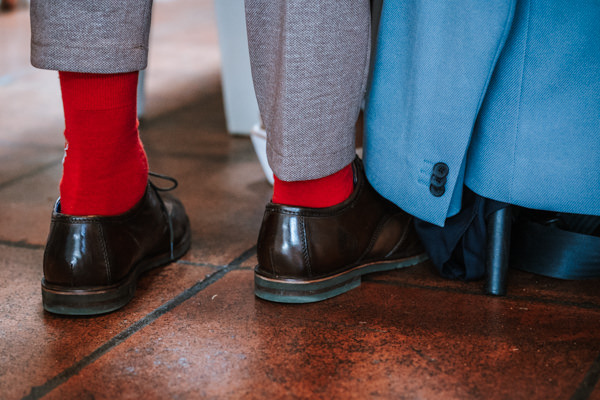 Nahaufnahme rote Socken in schwarzen Anzugschuhen bei Hochzeit in Freiburg
