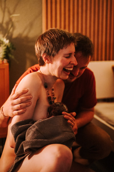 Eltern voller Freude und Stolz halten ihr Baby das erste Mal nach der Geburt